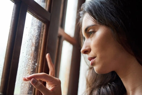 woman looking out a rainy window