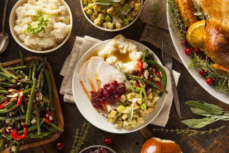 photo of a large holiday spread with turkey and mashed potatoes and several side dishes