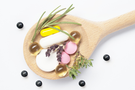 photo of a spoon with herbs and drug pills on it