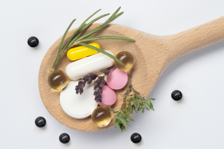 graphic showing supplements and drugs and herbs on a wooden spoon