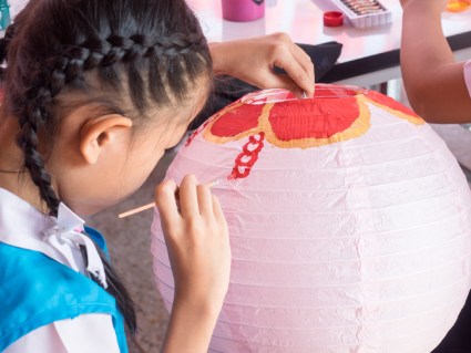 Photo of child painting a paper lantern